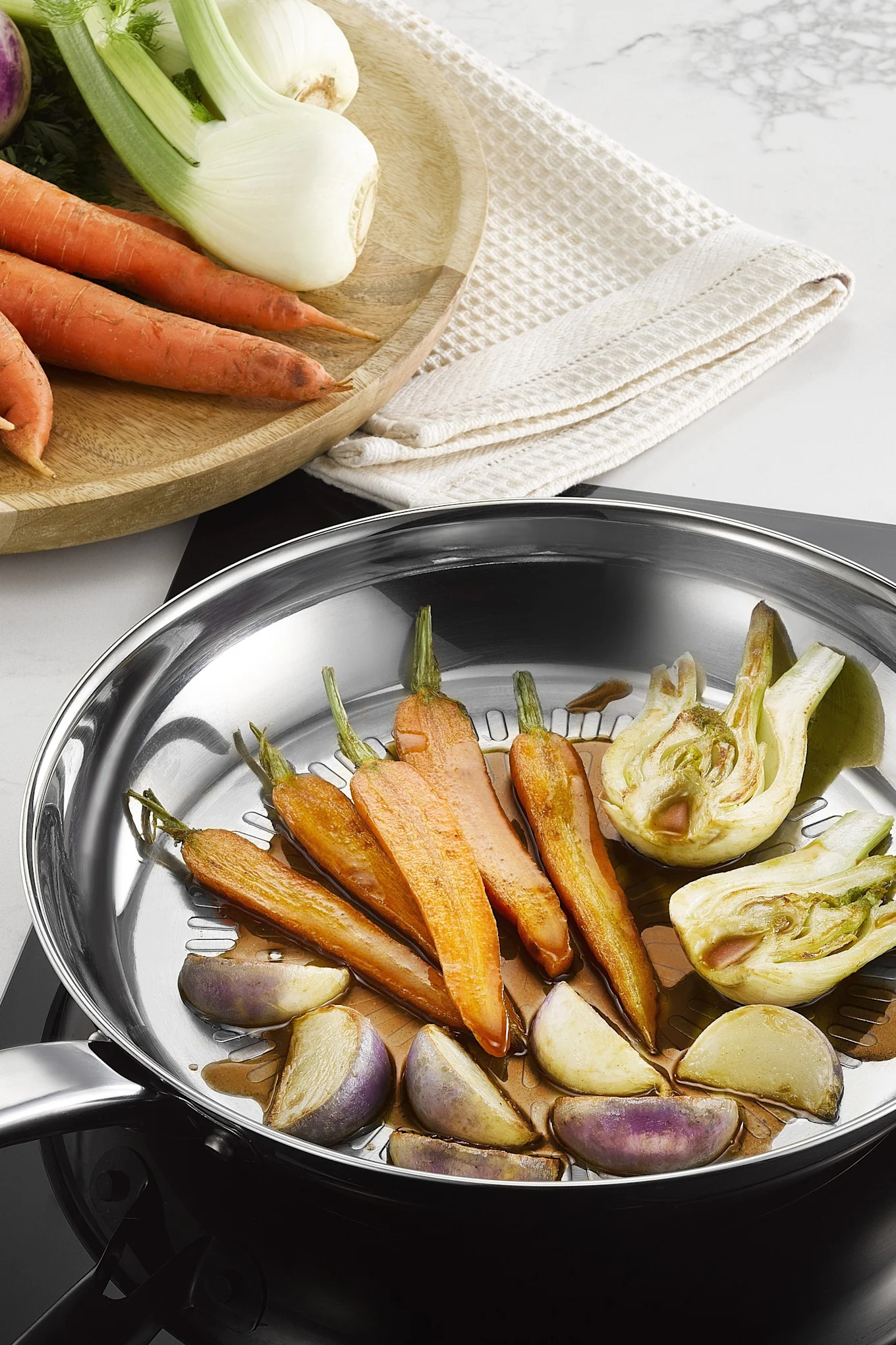 Ulike grønnsaker stekes i Intuition Techdome-pannen i rustfritt stål fra Tefal.