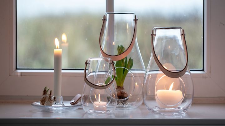 Pynt vinduskarmen: Design with Light-lanternene fra Holmegaard i ulike størrelser står på en vinduskarm.
