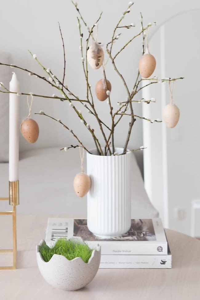 Påskepynt: Her ser du påskepynten fra Instagram-profilen @arkeniestetiikkaa, bestående av Kubus lysestaken fra Audo Copenhagen, Happy Easter-skålen og den hvite Lyngby-vasen med vårgrener – en stilfull og harmonisk kombinasjon for påskefeiringen!