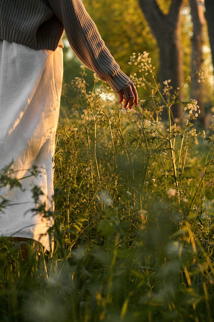 Midtsommer Orrefors - her ser du en kvinne som går i en blomstereng.