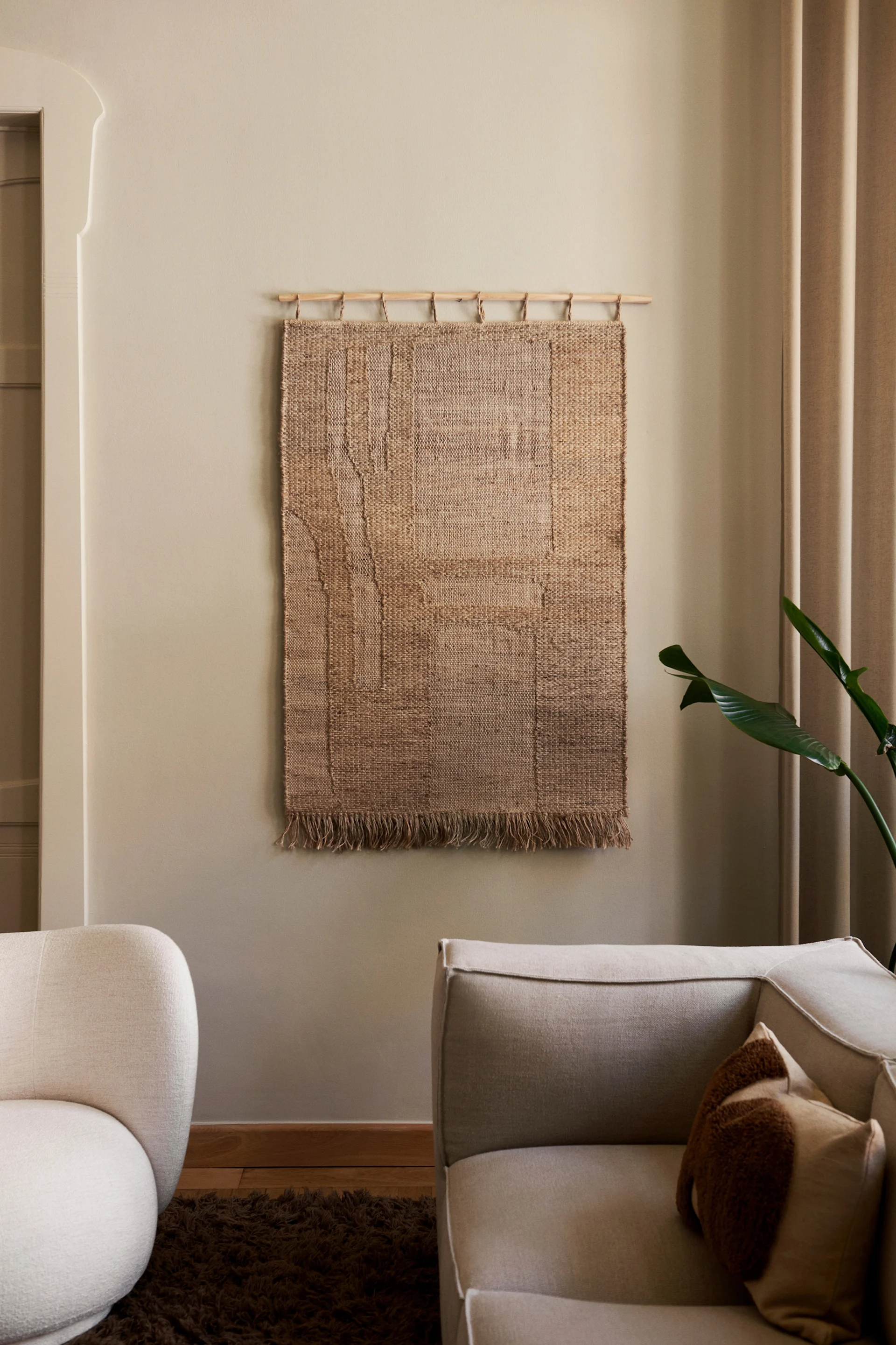 Dekorer veggen med Harvest veggdekor fra Ferm Living, her vist hengende i en stue på en nøytral vegg.