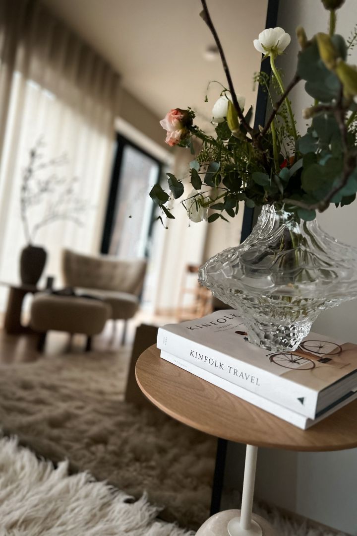 Influenser Helene Wold @villanyhus har dekorert &Tradition sidebord i hvitt og lyst tre med Skrufs vase med blomster på en stabel med bøker.