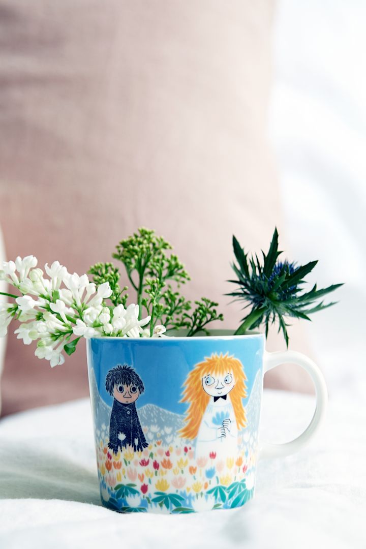 Mummikoppen «Friendship» står på et bord med blomster i.
