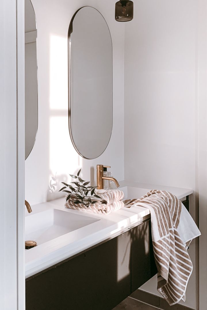 Det beige stripete håndkleet fra NJRD drapert over vasken i hjemmet til den svenske influenceren @arkihem. 