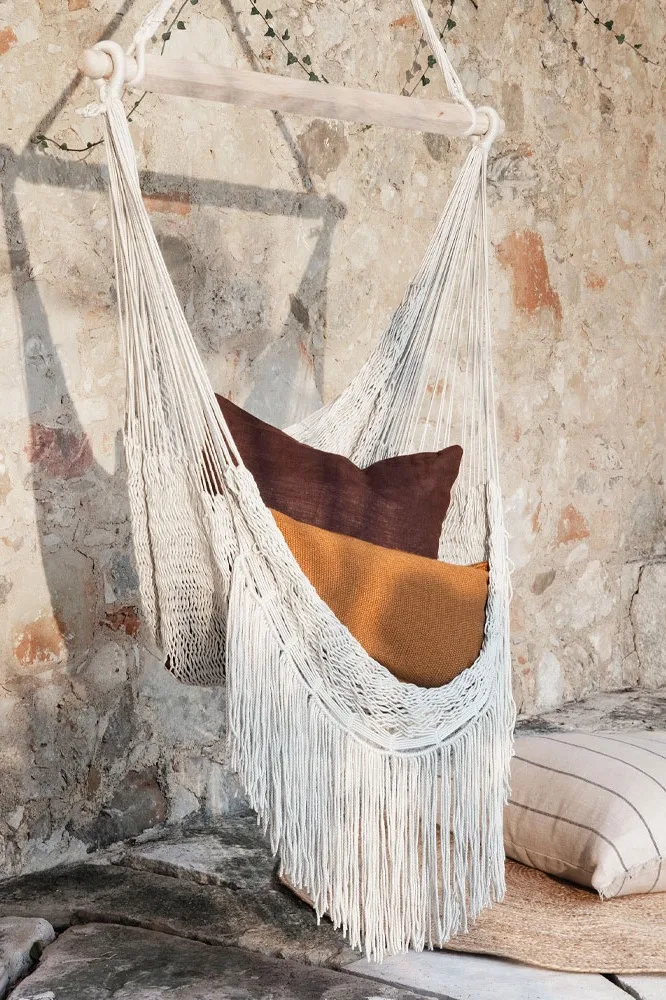 Tips til koselig uteplass - innred uteplassen din med koselige og myke tekstiler som ferm LIVINGs hengekøyestol som kan gynge deg til ro.