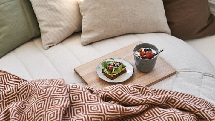 Yoghurten og frokostsmørbrødet venter på å nytes til en koselig frokost på senga blant myke puter og varme tepper fra Scandi Living.