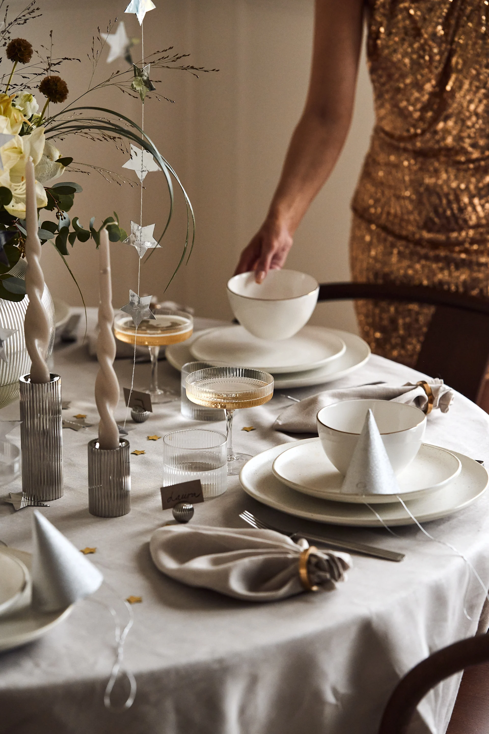Årets nyttårsbord 2024 har en stilren lys base med tallerkener og skåler fra Ernst, Olsson & Jensen og detaljer med ribbet struktur.