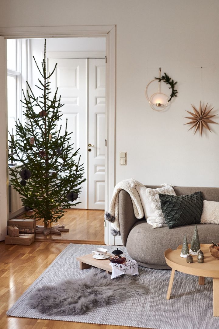 En stue i hvitt og grønt viser hvordan julepynt kan være både stilig og minimalistisk.