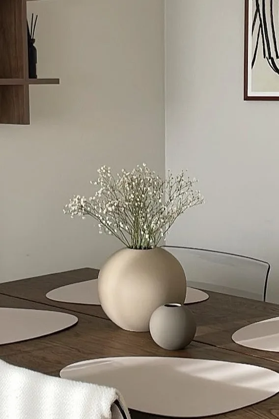 Ballvasen i sand og grått, i to forskjellige størrelser står på et spisebord i spisestue i nøytrale farger.