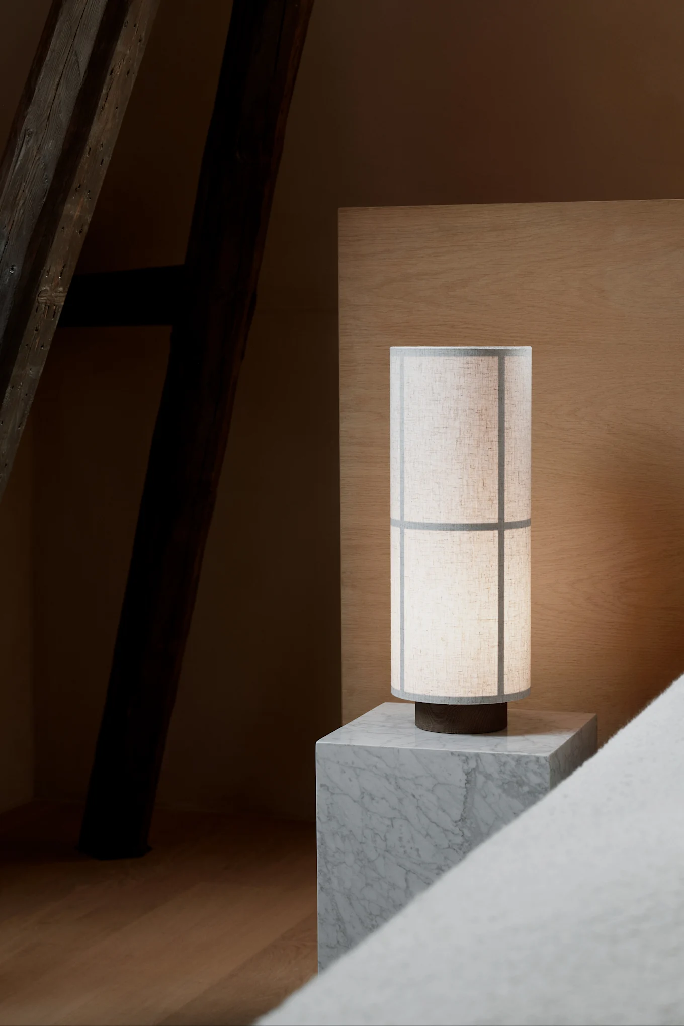 På et grått nattbord i marmor står Hashira-bordlampen fra Audo Copenhagen, inspirert av Japandi-stilen.