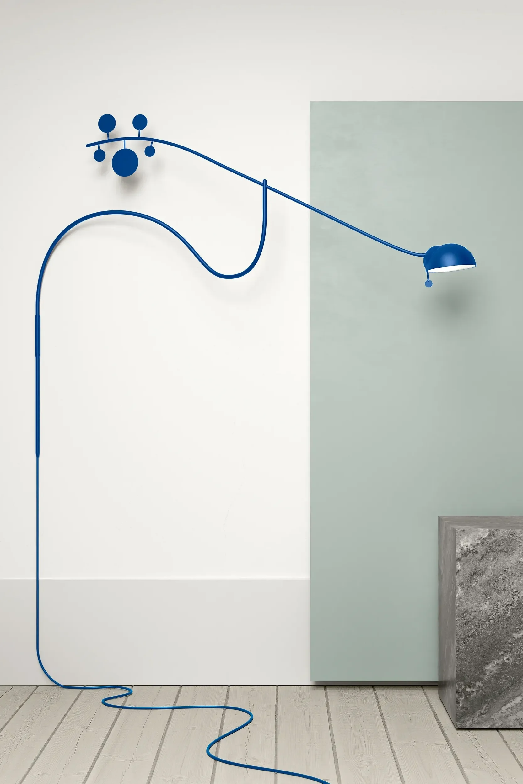 En blå Juno-vegglampe fra NOON sitter montert på veggen og gir interiøret et friskt fargeinnslag, i tråd med fargetrender interiør 2026.
