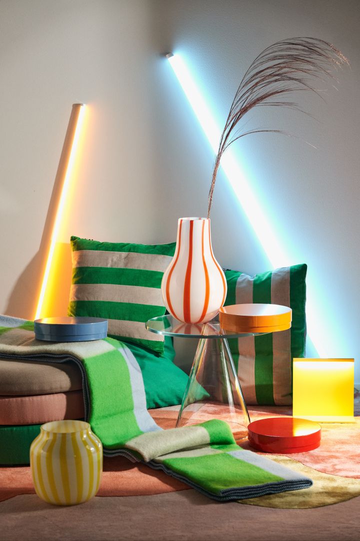 Fargetrender 2024 - interiørdesign som går i neonfarger, her to stripete vaser i neongult og oransje fra HAY og Broste Copenhagen.