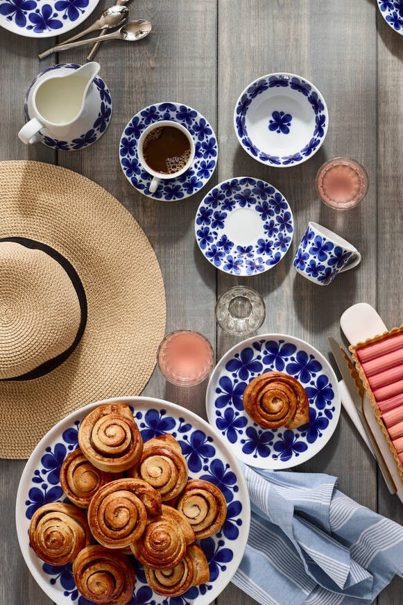 Svenske kanelbullar er det mest kjente fika-bakverket, også utenfor Sveriges grenser. Her ser du dem servert på Rörstrands Mon Ami-servise på et utebord med sommerhatt.