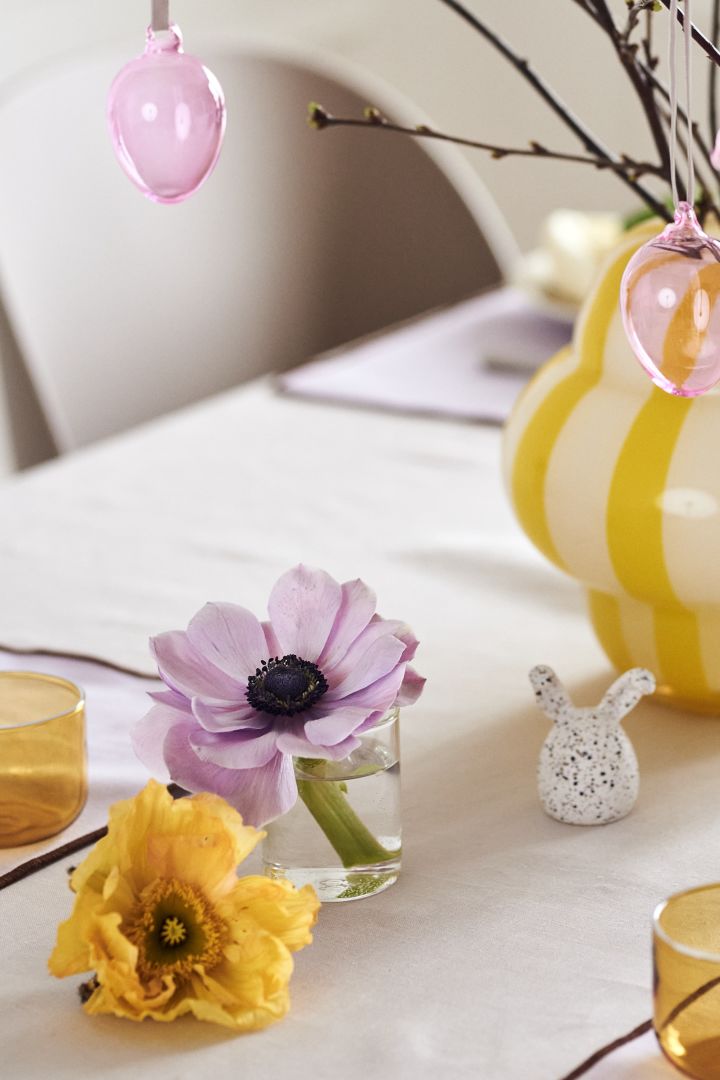 Lag et festlig påskebord i vårlige pasteller med fine snittblomster, fargerike glassegg fra Iittala og påskeharer fra DBKD.