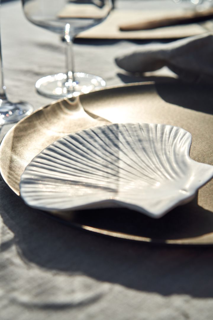 Noen festlige tips til det svenske krepselaget er å brette fine servietter og dekke bordet med havet som inspirasjon, som med denne Shell-tallerkenen fra By On. 