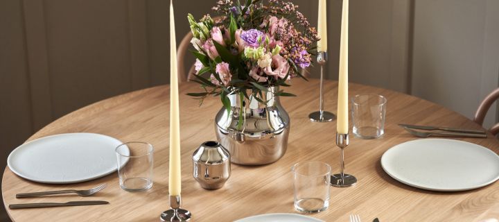Den nye serien for Gense designet av Monica Förster, her ser du de to vasene i polert rustfritt stål og lysestaker i en enkel borddekking.