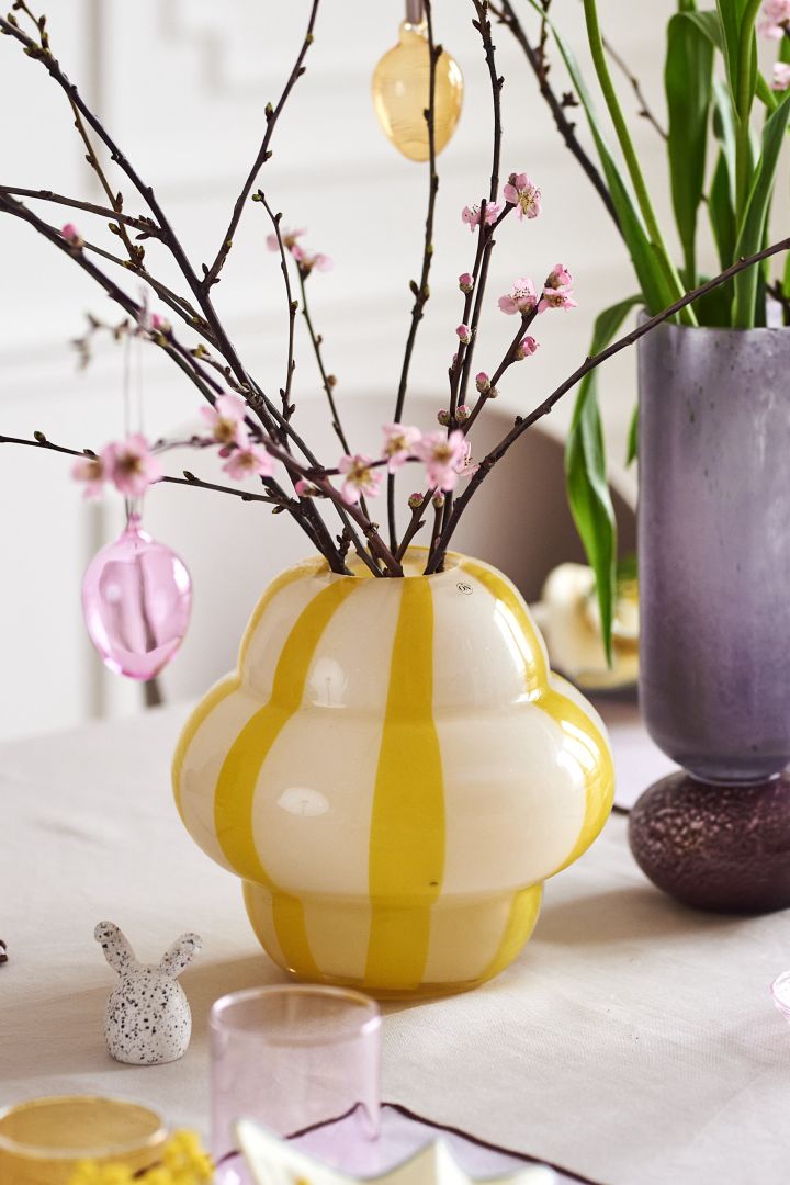 Lag et festlig påskebord i vårlige pasteller med Iittalas fargerike glassegg på et vakkert påskeris i Curlie-vasen fra By On.