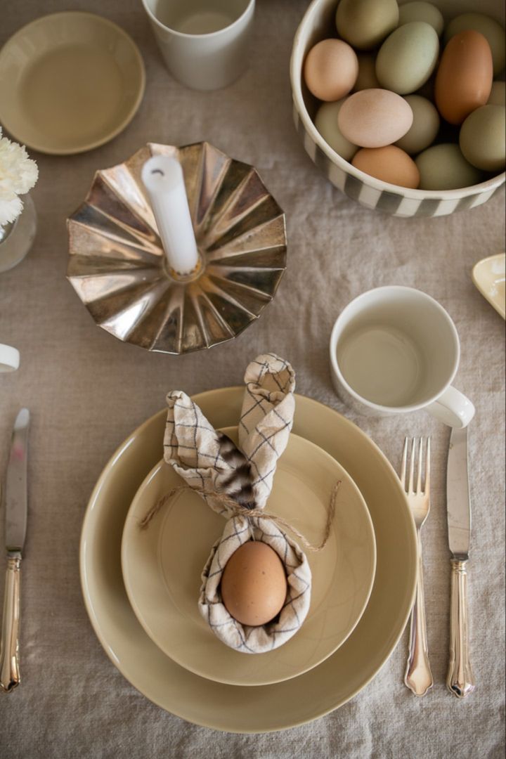 Hvordan brette servietter - en serviett brettet som kaninører med et egg plassert i midten.
