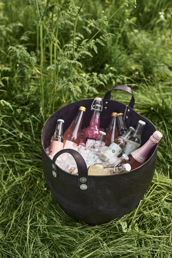 En borddekking i hagen er ikke komplett uten praktisk oppbevaring. Her ser du den Dacarr oppbevaringskurv fra Muubs som er perfekt til sommerfestens drikker.