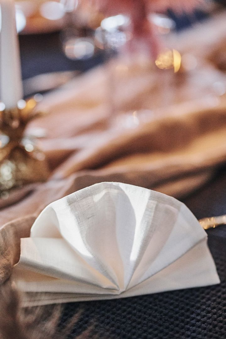 Brette servietter som en vifte til fest, jul og nyttår med hvit linserviett.