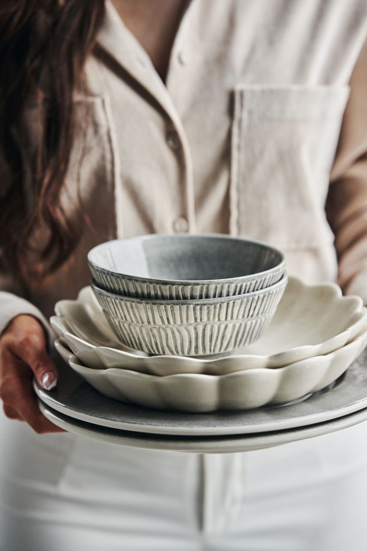 Et dekket bord med grå Stripes skåler, beige Oyster østersskål i fargen sand, sammen med grå Basic tallerkener fra Mateus.