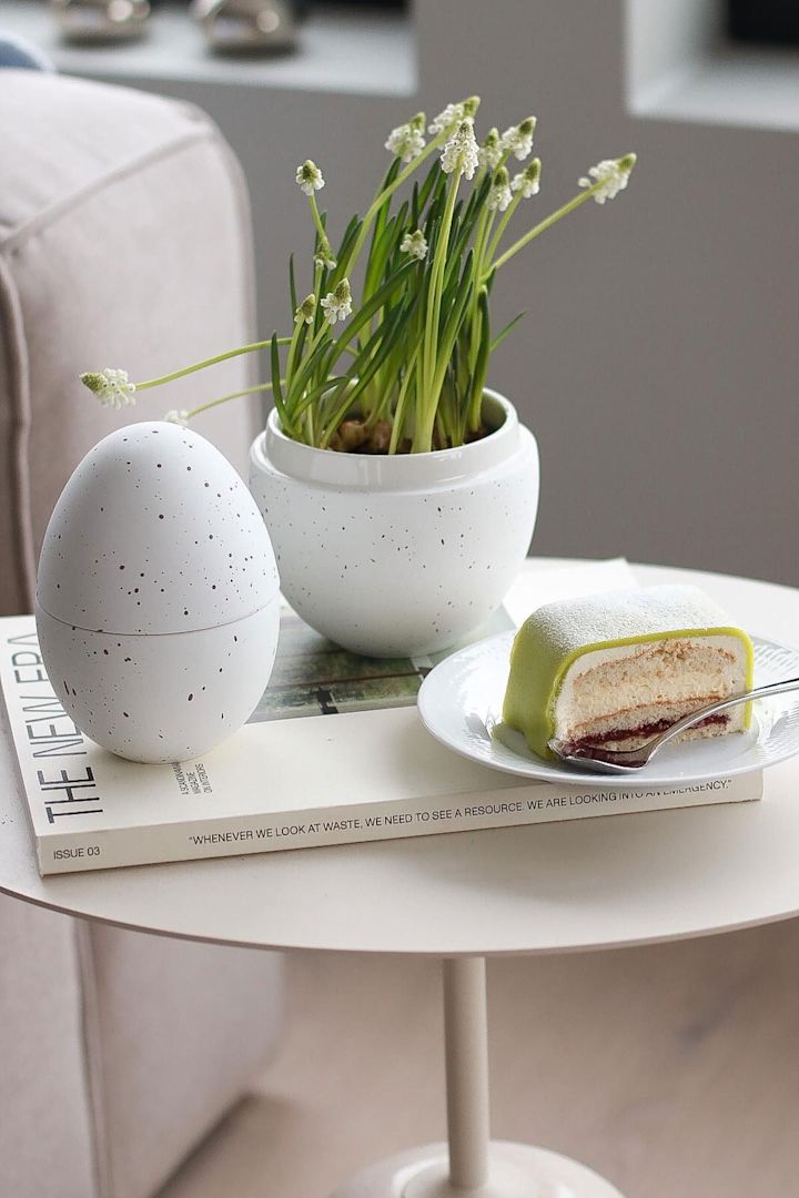 Påskepynt: På et sidebord står den hvite bonbonnieren med blomster fra Cooee Design, ved siden av en tallerken med prinsesstårta, hjemme hos @picsbyellen.