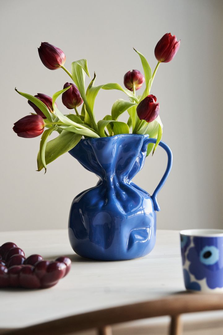 Innred i henhold til interiørtrender høsten 2023 og krydre interiøret ditt med aksenter i kornblått - her Crumble-vasen fra By On med røde tulipaner.