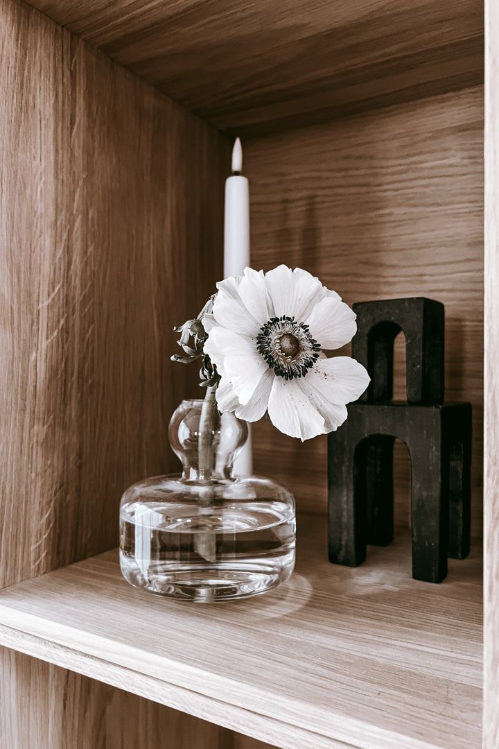 Innrede bokhylle - inspirasjon hjemme hos Anela Tahirovic @arkihem der en snittblomst i en fin Marimekko-vase skaper et mer levende inntrykk i bokhylla di.