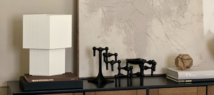 Stilleben med interiørdesign i form av en hvit Japandi-inspirert lampe fra Pholc og STOFF i sort.