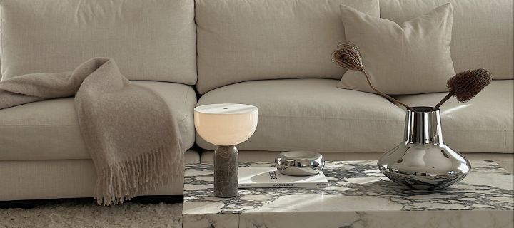 Influenceren Helena Jonsson @helenas.hem har innredet med minimalistisk interiør i stuen med sølvvase, bærbar belysning og stuebord i marmor. 