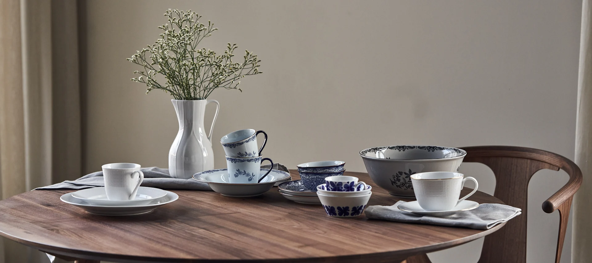 Blandet porselen av Rörstrand på et bord laget av valnøtttre.
