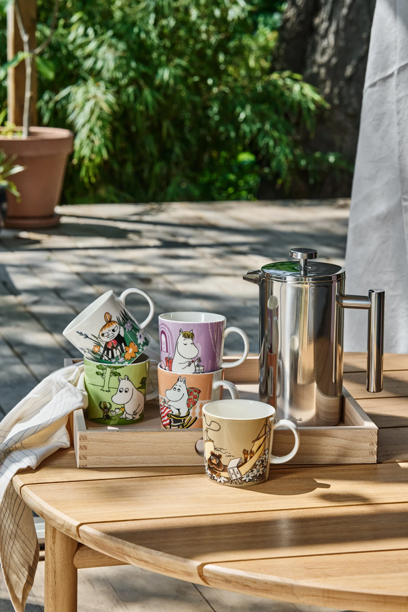 Flere mummikopper står på et bord i hagen.
