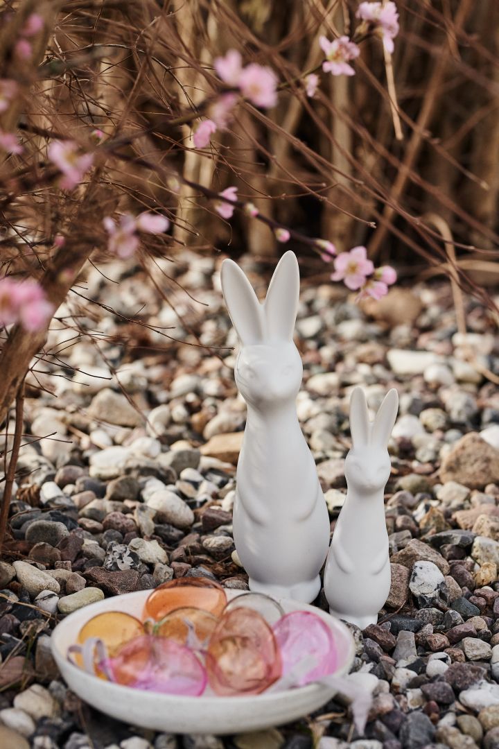 Påskepynt fra DBKD i form av påskeharer og egg i forskjellige farger fra Iittala står i hagen som en del av en pågående påskeeggjakt.