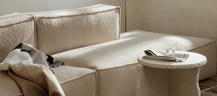 Beige stue med sofa, stuebord og koselig pledd fra Ferm Living. 