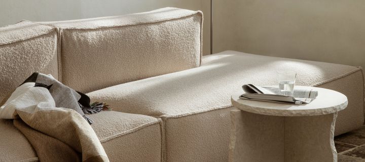 Beige stue med sofa, stuebord og koselig pledd fra Ferm Living. 