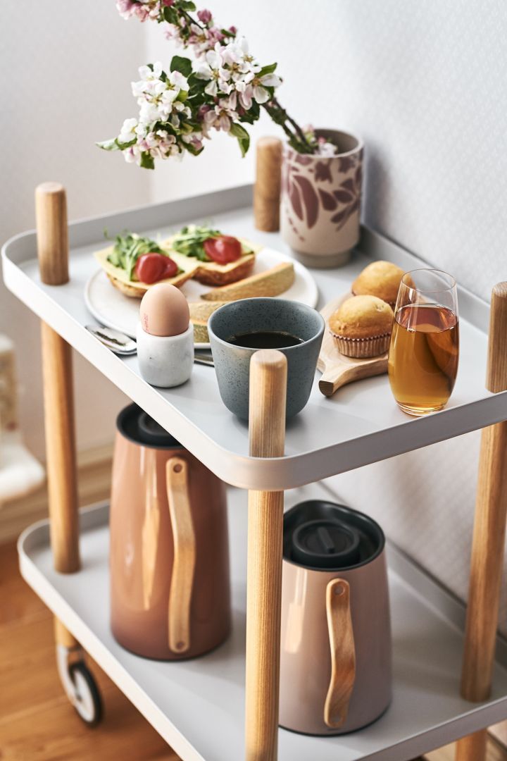 En virkelig luksuriøs frokost med kaffe, egg og smørbrød serveres på et sidebord for en deilig frokost på senga.
