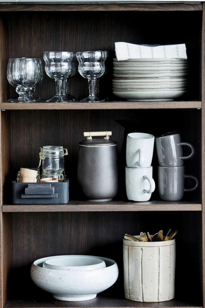 Stilleben i kjøkkenskapet med glass, kopper, skåler og tallerkener i rustikk stil fra House Doctor.