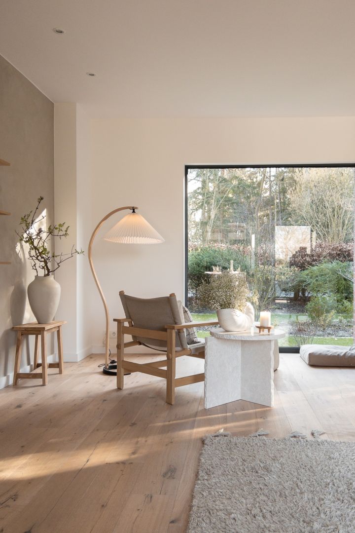 Skap et hjem i skandinavisk stil- her ser du stuen fra @haus_tannenkamp med den buede Gubi-lampen og det hvite Mineral-bordet fra Ferm Living.