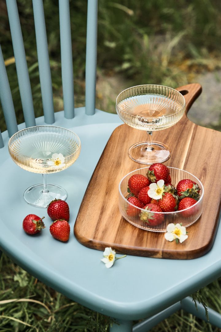 Champagneskåler er perfekte å bruke til avkjølende sommerdrinker som kan serveres med en bolle med jordbær ved siden av.
