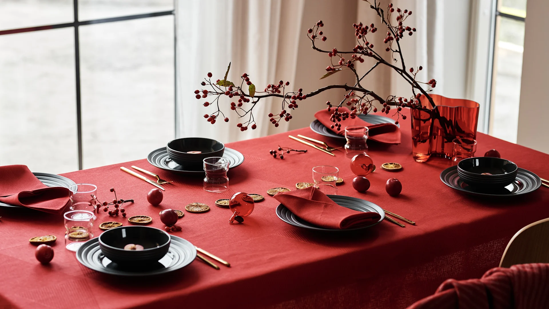 Skap en stemningsfull borddekking jul 2025 med en rød linduk som base, komplettert med moderne, svart servise og røde linservietter for et tidløst, men trendy uttrykk.
