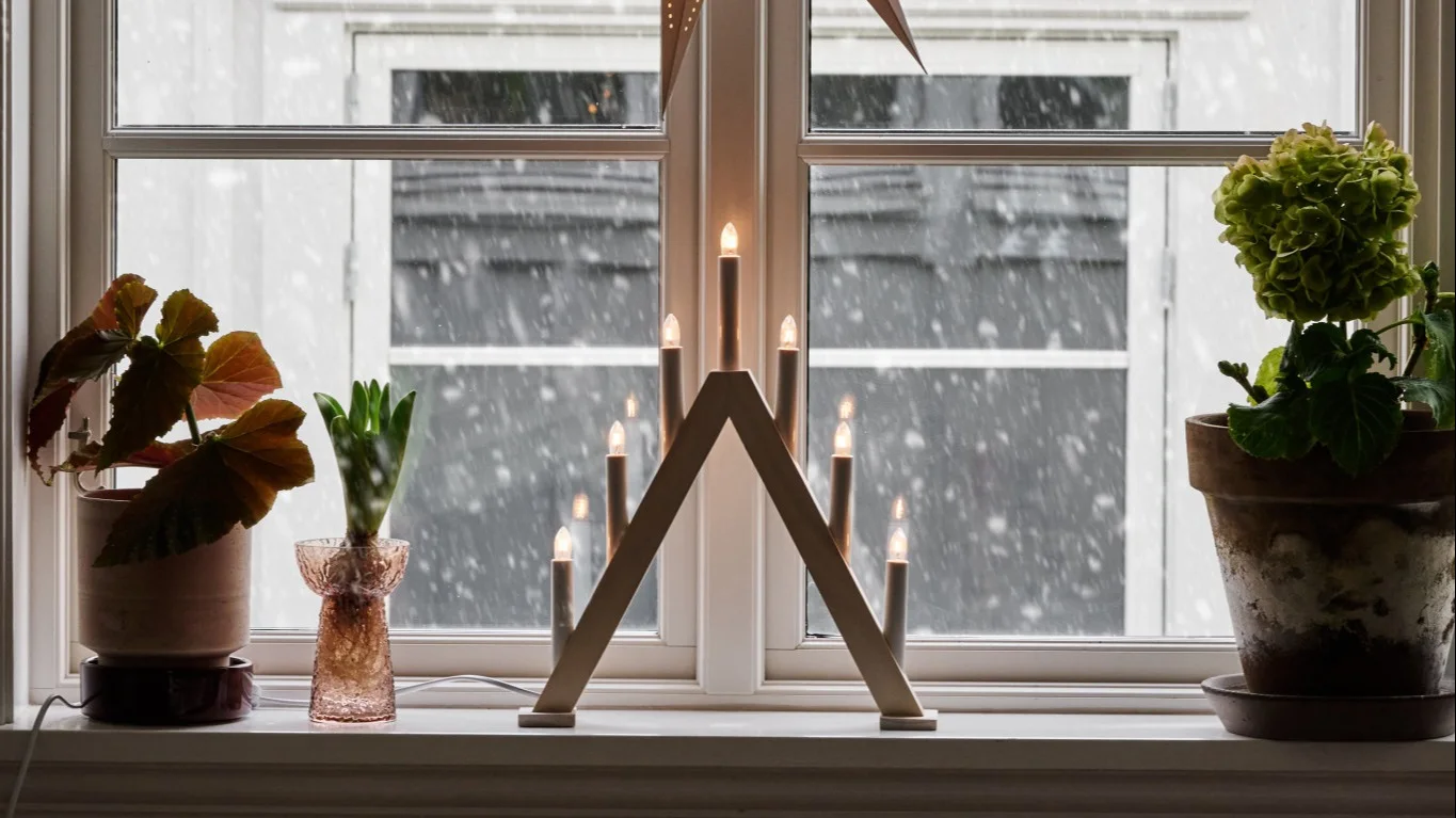 Pynt vinduskarmen ved å gruppere ulike objekter i forskjellige størrelser og høyder, for eksempel en bordlampe, vaser med blomster og lysestaker.
