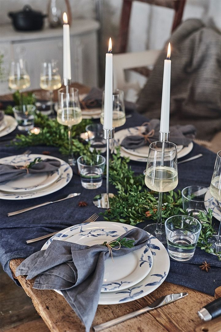Romantisk borddekking på julaften i blått med blått og hvitt servise fra Nordic Nest Dining & lysestaker fra Cooee Design.