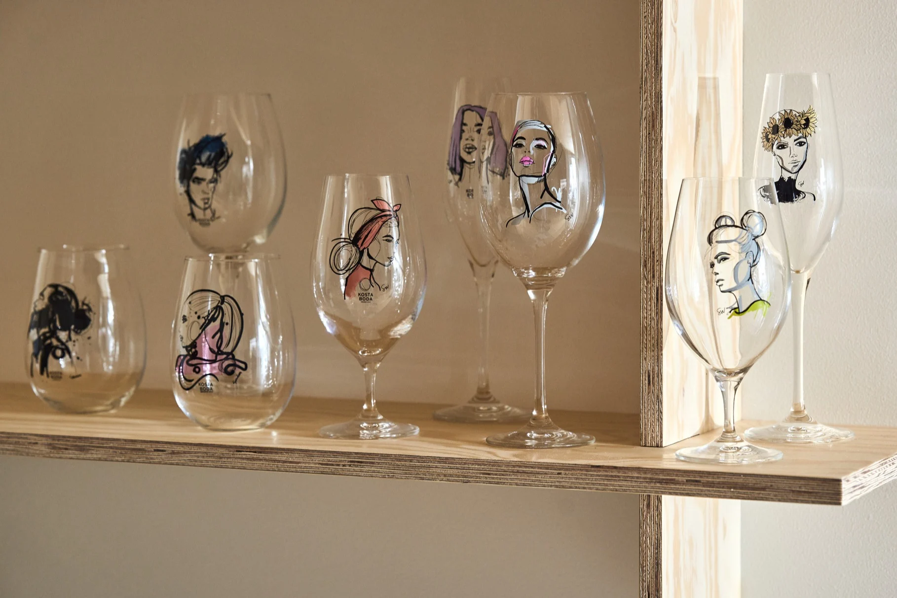 En samling glass fra All About You-serien står på en hylle i kryssfiner.