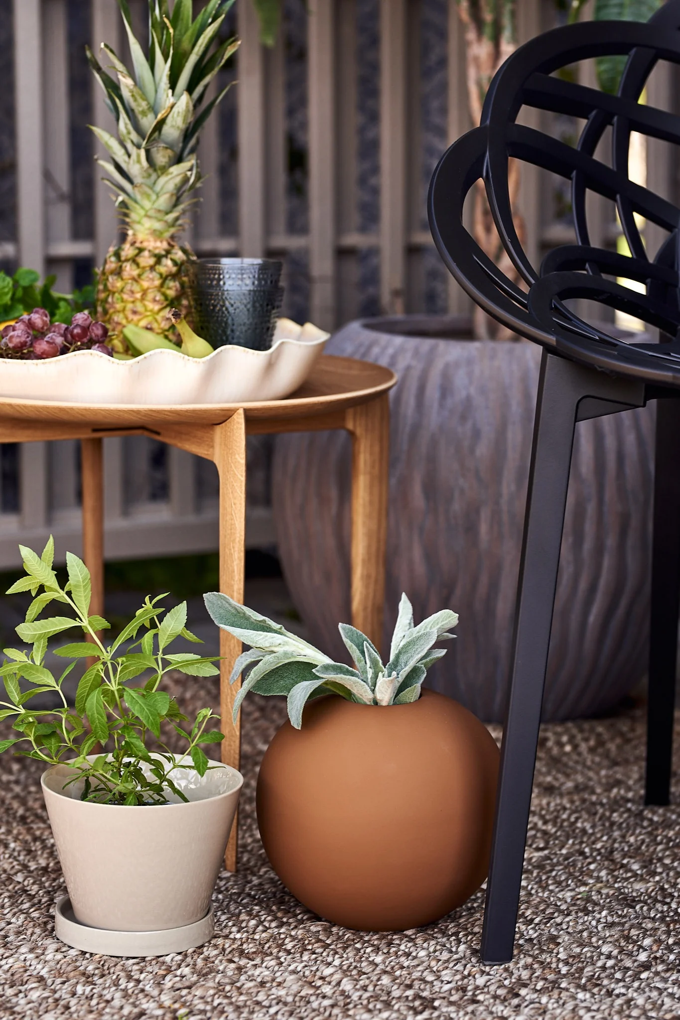 ERNST krukke og Cooee Design vase i brunt på en uteplass.