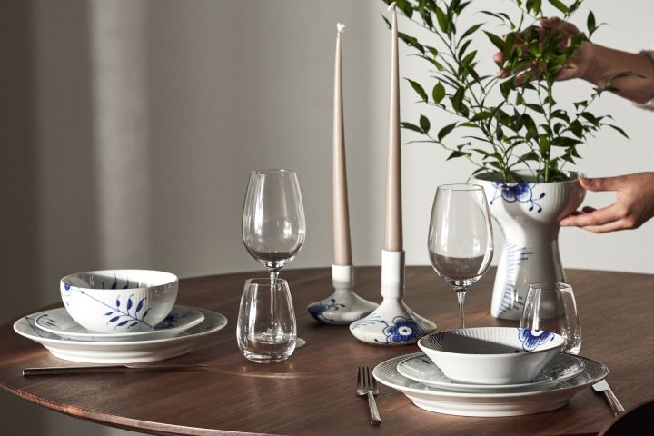 Et dekket bord med Blue fluted mega tallerkener, skåler, lysestaker og vase fra Royal Copenhagen i klassisk blått og hvitt.