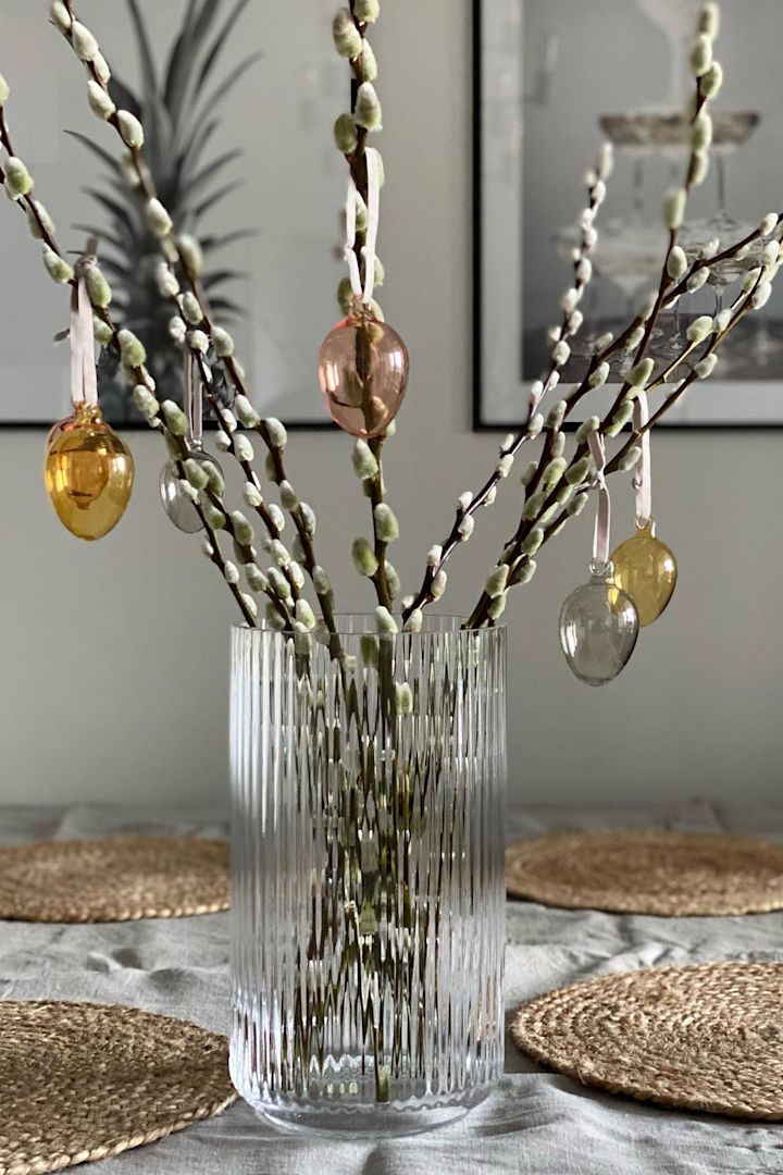 Påskepynt: Iittala-glasseggene henger fra en påskeriskvist i en Lyngby-glassvase fra Lyngby Porcelæn hjemme hos @marinaslgh. En elegant og tidløs påskepynt som skaper en stilren vårstemning!