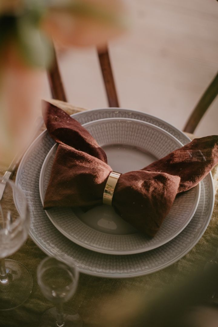 Hvordan brette servietter - her ser du en brun linserviett brettet til en sløyfe.