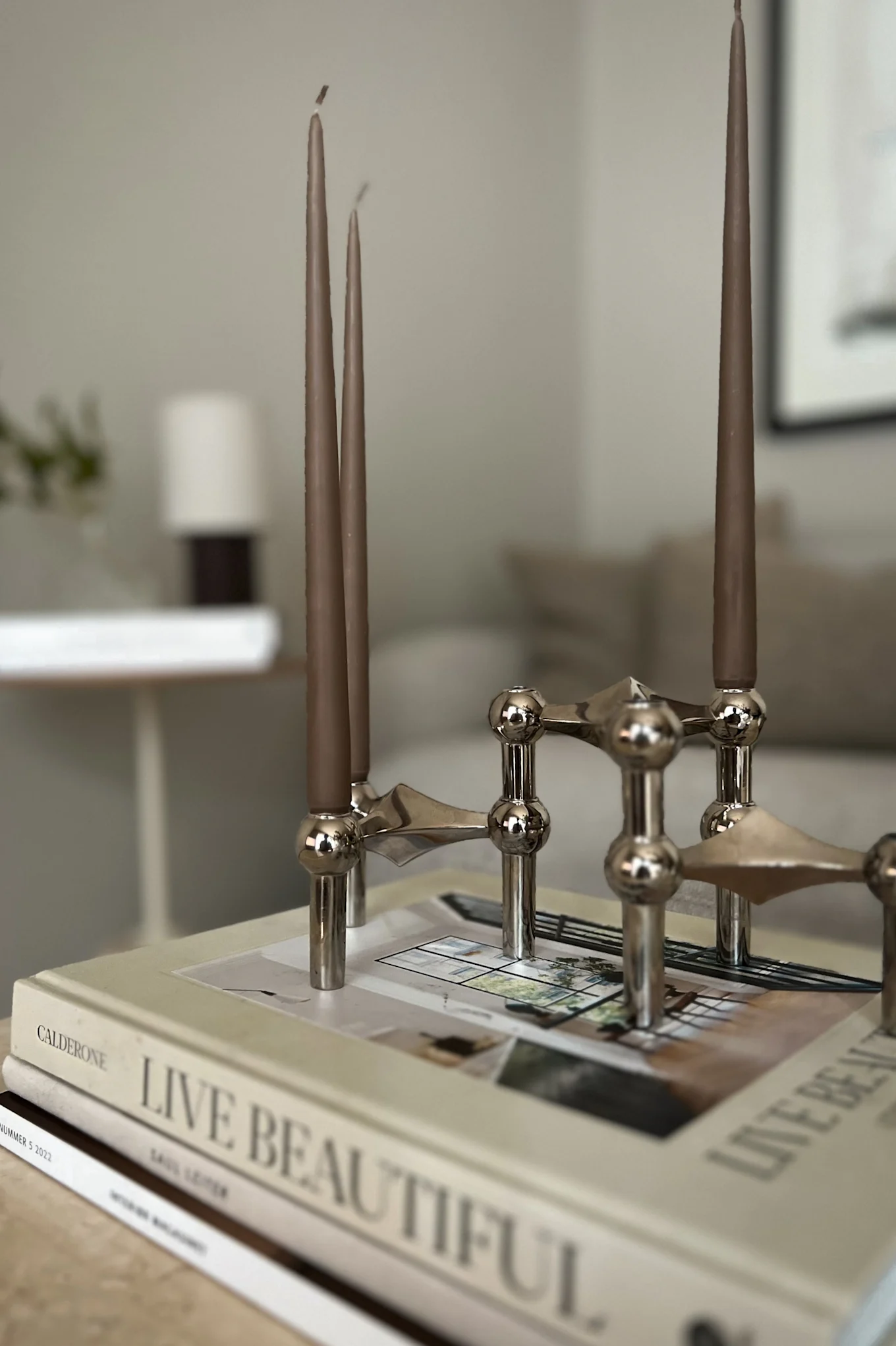 Influenser Helene Wold @villanyhus har innredet stuen med Stoff lysestaker i krom sammen med brune lys som gir hjemmet et moderne preg.