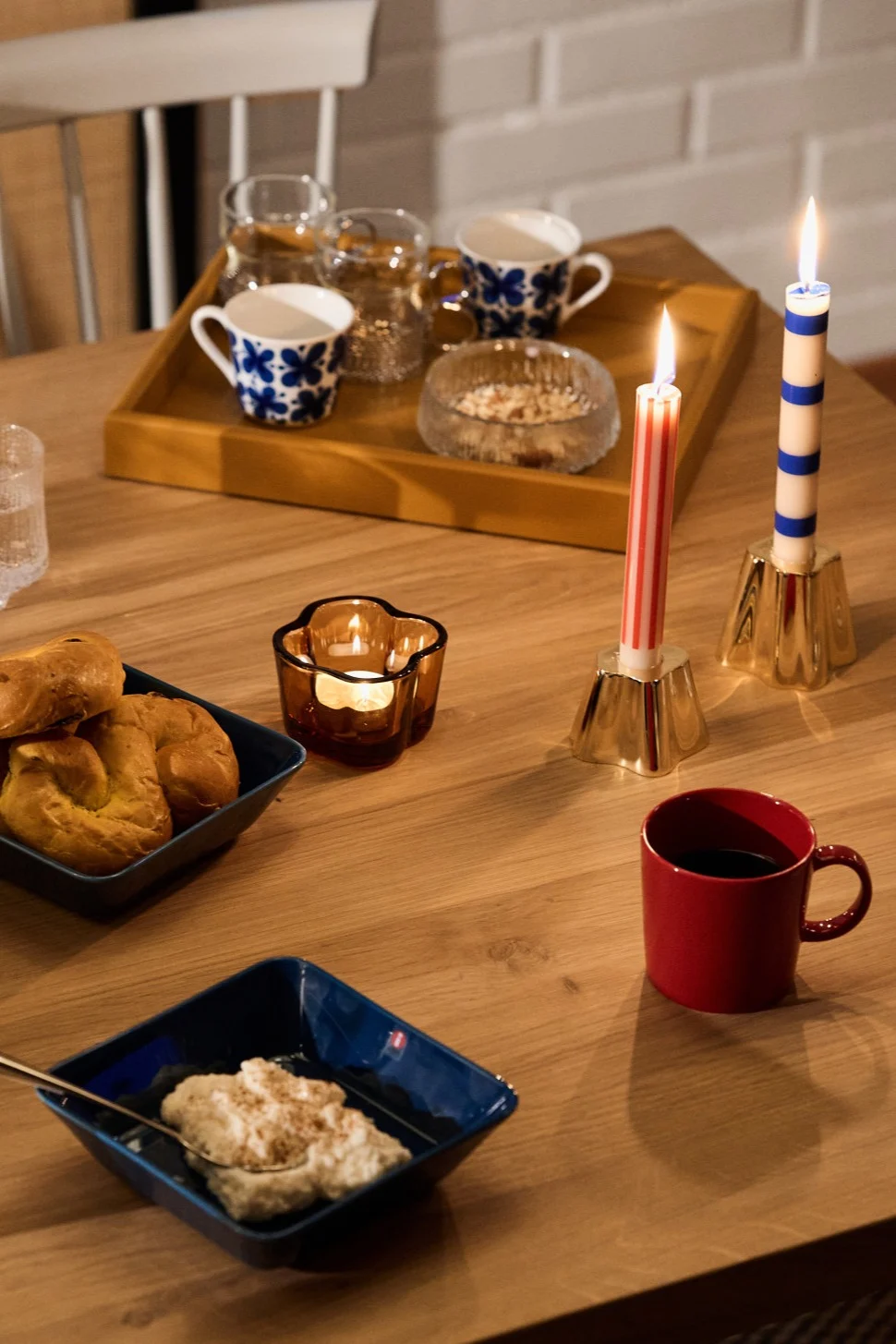 Vintage røde og blå Teema krus og skåler sitter ved siden av de stripete røde og blå lysene fra HAY, en del av vår vintage julepynt.