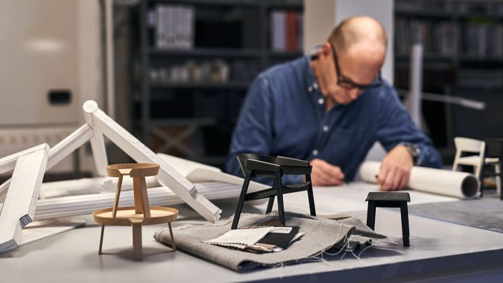 Thomas Bentzen skisserer i sitt studio i København med prototyper av Cover-stolen og Around-bordet rundt seg.